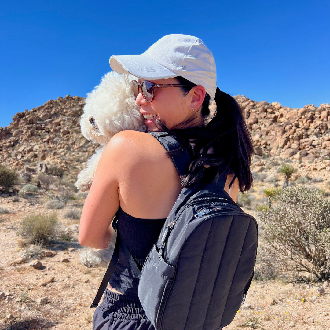 woman with dog with black hydration backpack at joshua tree