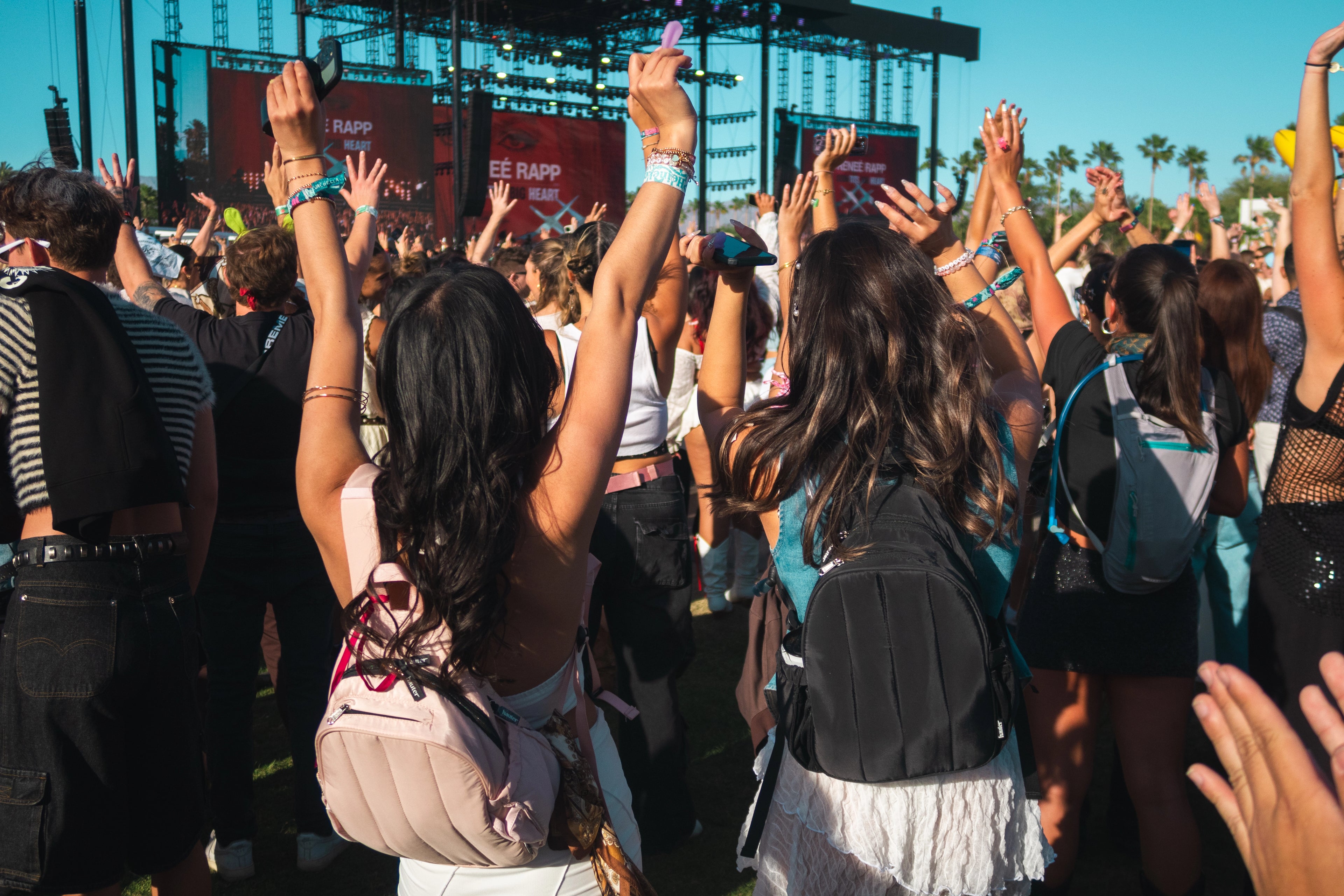 two woman with backpacks at coachella music festival